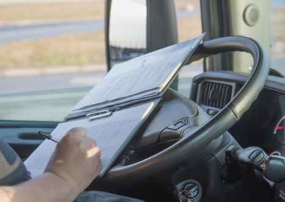 Truck driver is writing in the ocumentation.